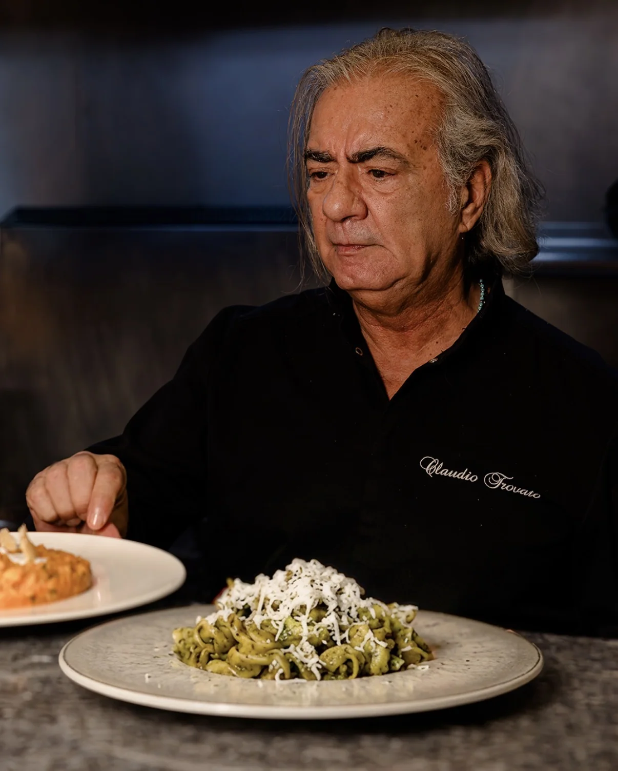Lo chef con due piatti di pasta.