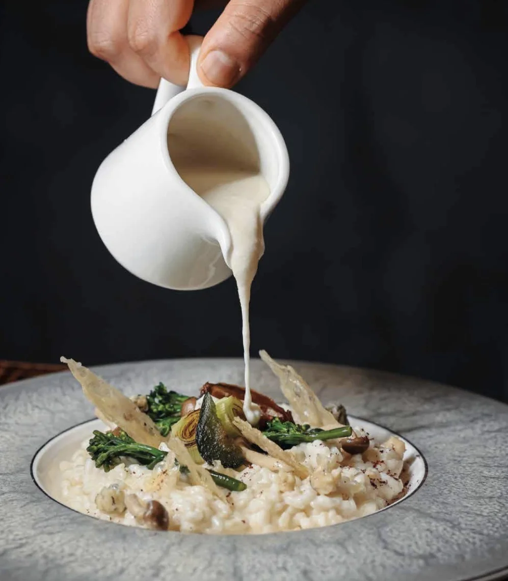 Risotto cremoso con salsa versata, broccoletti e cialde croccanti.